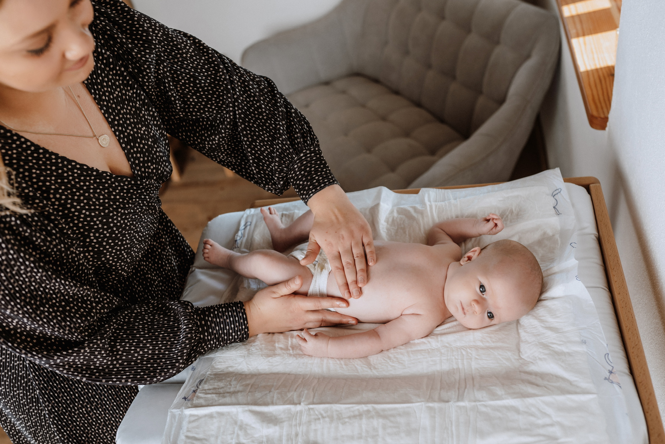 Hände der Hebamme auf Baby